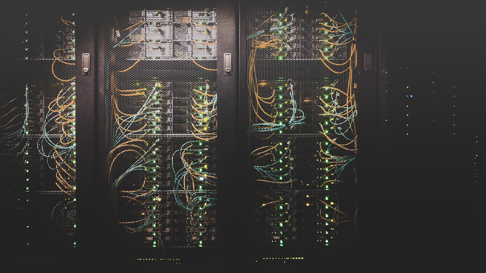 Server racks in a dark data centre with status lights