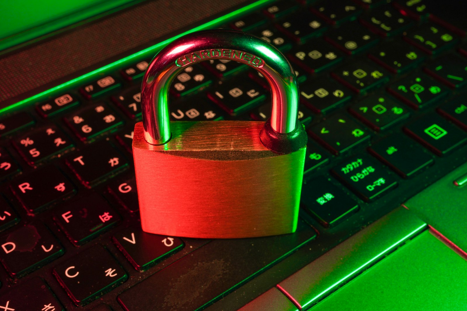 Padlock resting on a computer keyboard lit in red and green